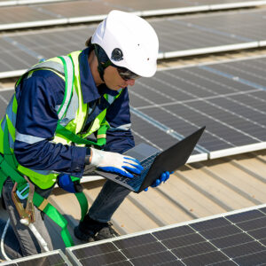 Tecnico al lavoro fra moduli fotovoltaici su un tetto